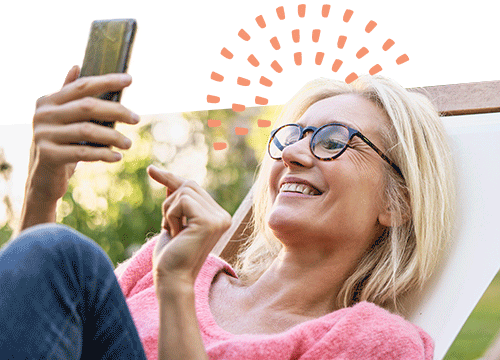 woman sitting on chair while using cell phone