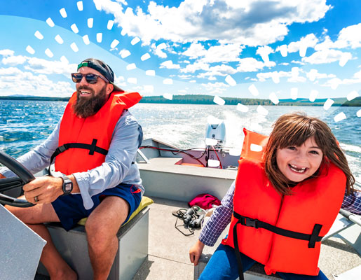 A father with his young daughter on a boat, smiling