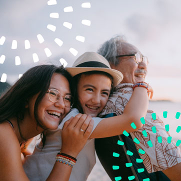 A family hugging each other and happily smiling at something in the distance